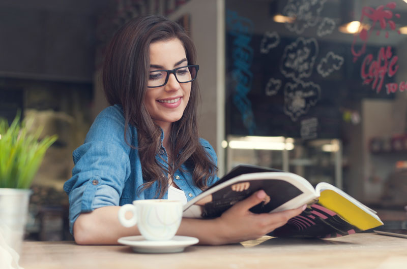 mujer-leyendo en una cafeteria-con-un-cafe