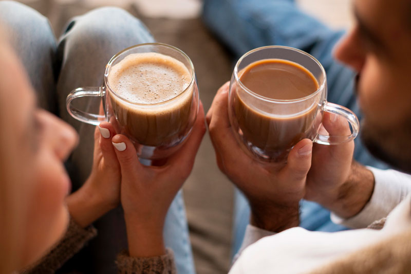 hombre y mujer con vasos de café